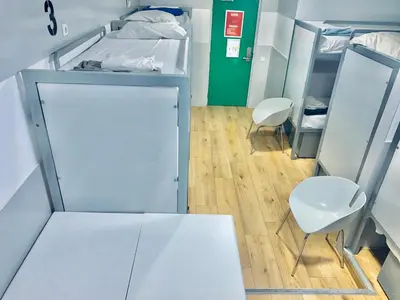 a hospital room with two beds and two chairs at The White Tulip Hostel in Amsterdam