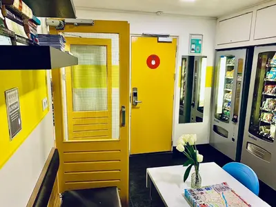 a room with a yellow door and a table in a store at The White Tulip Hostel in Amsterdam