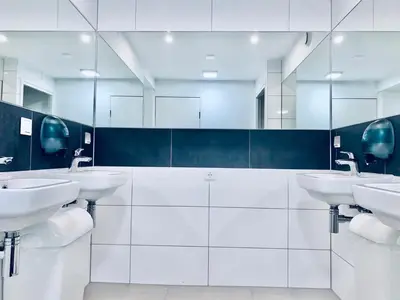 a white bathroom with four sinks and mirrors at The White Tulip Hostel in Amsterdam