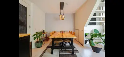 a dining room with a wooden table and some plants at Spacious 3-Bedroom Apartment Amsterdam West - by Peter in Amsterdam