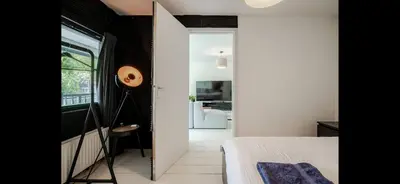 a bedroom with a bed and a view of a living room at Spacious 3-Bedroom Apartment Amsterdam West - by Peter in Amsterdam