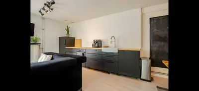 a living room with a couch and a kitchen at Spacious 3-Bedroom Apartment Amsterdam West - by Peter in Amsterdam