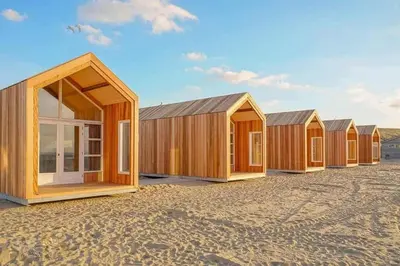 a row of wooden houses sitting in a field at Sisters Beachbungalows in Katwijk aan Zee