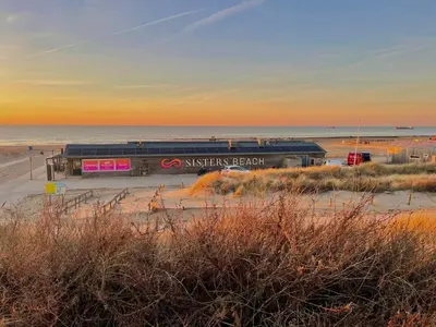 a train station on the beach at sunset at Sisters Beachbungalows in Katwijk aan Zee