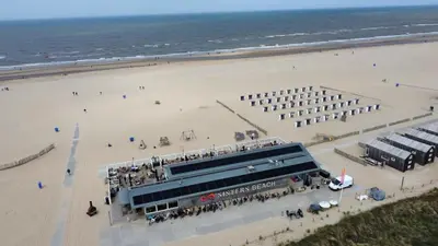 a building on the beach next to a beach at Sisters Beachbungalows in Katwijk aan Zee
