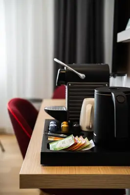 a desk with a coffee cup and a printer on it at IntercityHotel Leiden in Leiden