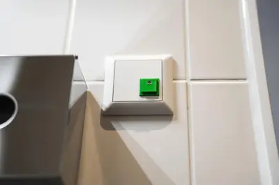 a green and white clock on a tiled wall at IntercityHotel Leiden in Leiden