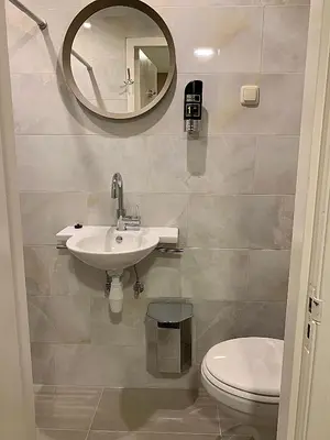 a bathroom with a sink and a toilet and a mirror at Hotel Damrak Inn in Amsterdam