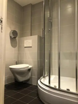 a bathroom with a toilet and a glass shower at Hotel Damrak Inn in Amsterdam