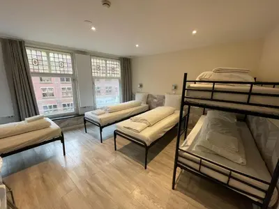 a room with four bunk beds in it at Hotel Damrak Inn in Amsterdam