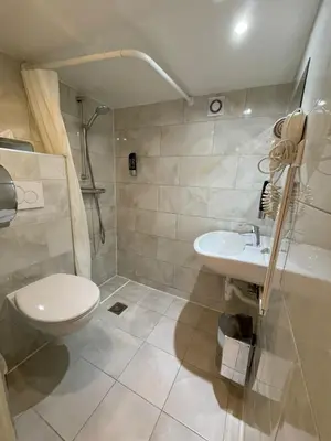 a bathroom with a toilet and a sink at Hotel Damrak Inn in Amsterdam
