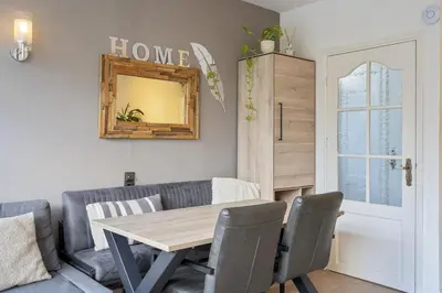 a dining room with a table and a couch at Palm Beach House in Zandvoort