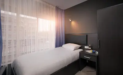 a bedroom with a white bed and a window at Belfort Hotel in Amsterdam