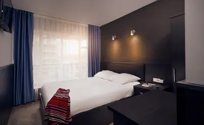a hotel room with a bed and a window at Belfort Hotel in Amsterdam