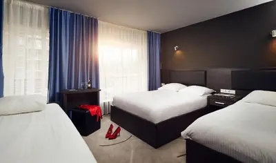 a hotel room with two beds and a window at Belfort Hotel in Amsterdam