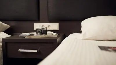 a camera on a night stand next to a bed at Belfort Hotel in Amsterdam