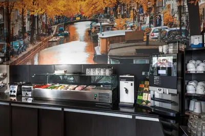 a restaurant counter with a picture of a city at Belfort Hotel in Amsterdam
