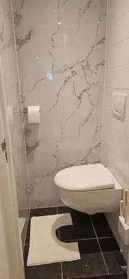 a bathroom with a toilet and a marble wall at Il Mulino House A in Lisse