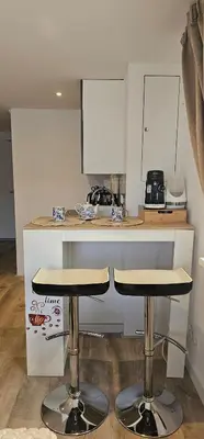 a kitchen with two bar stools in front of a counter at Il Mulino House A in Lisse