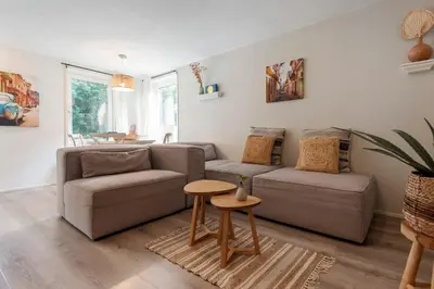 a living room with a couch and a table at Historical Tiny Home (+Private Sauna) in Zandvoort