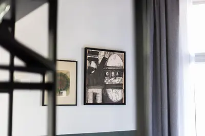 two framed pictures on a wall next to a window at Weber Hotel 397 in Amsterdam