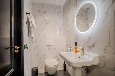 a white bathroom with a sink and a toilet at Boutique Pension Code Rosé in Noordwijk