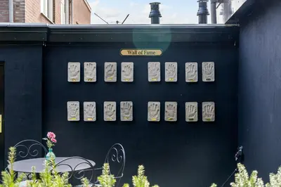 a wall with a bunch of japanese plates on it at Boutique Pension Code Rosé in Noordwijk