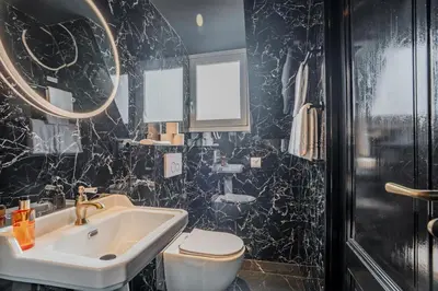 a black and white bathroom with a sink and a toilet at Boutique Pension Code Rosé in Noordwijk