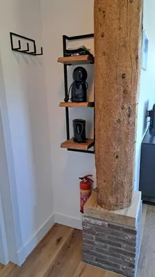 a wooden column in a room with wooden shelves at Aan de Dijk in Edam