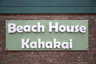 a sign for a beach house khalili on a brick wall at Kahakai Beach House - Unique Outdoor Kitchen - next to local lake and 15 min. the from beach in Noordwijkerhout