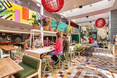 a restaurant with people sitting at tables at Stayokay Hostel Amsterdam Oost in Amsterdam
