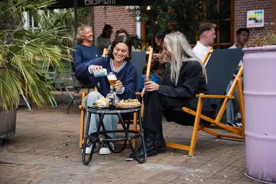 two women sitting in rocking chairs with a table at Stayokay Hostel Amsterdam Oost in Amsterdam
