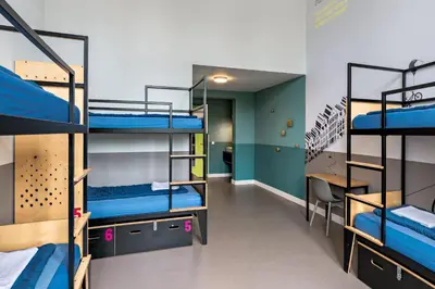 a dorm room with bunk beds and a desk at Stayokay Hostel Amsterdam Oost in Amsterdam