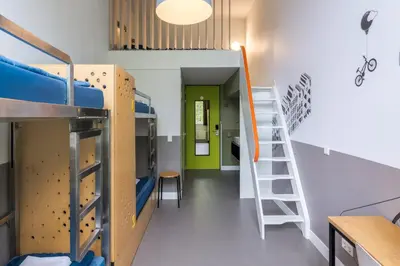 a dorm room with bunk beds and a ladder at Stayokay Hostel Amsterdam Oost in Amsterdam