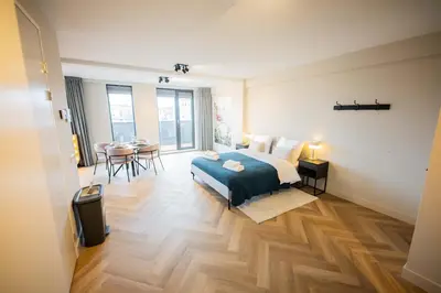 a bedroom with a bed and a table and chairs at Alphabet Apartments - Kerkstraat 71 in Hilversum