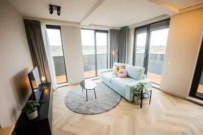 a living room with a couch and a teddy bear at Alphabet Apartments - Kerkstraat 71 in Hilversum
