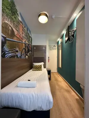a large bed in a room with a green wall at ITC Hotel in Amsterdam