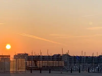 a sunset over a city with buildings in the background at DD 58 - Camping de Duindoorn - AIRCO in IJmuiden