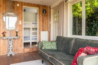a living room with a couch and a mirror at Holiday home Landelijk Amsterdam in Amsterdam