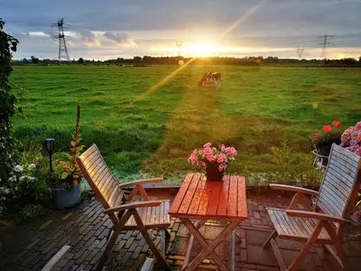 a table with two chairs and a table with flowers at Holiday home Landelijk Amsterdam in Amsterdam