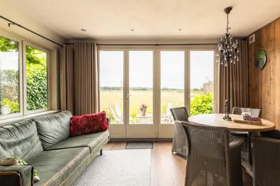 a living room with a couch and a table at Holiday home Landelijk Amsterdam in Amsterdam