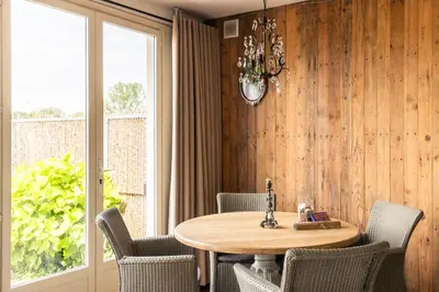 a dining room with a table and chairs and a window at Holiday home Landelijk Amsterdam in Amsterdam