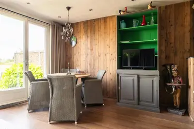a dining room with a table and chairs and a television at Holiday home Landelijk Amsterdam in Amsterdam