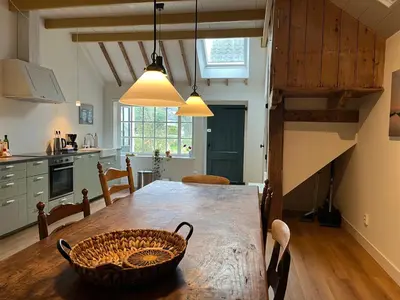 a kitchen with a wooden table with a basket on it at Kleinhoef - charmante, luxe kamers in een boerderij uit 1875 in Nigtevecht