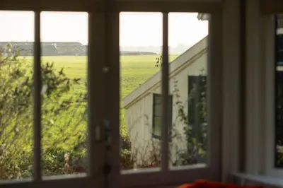 a window view of a field from a house at Kleinhoef - charmante, luxe kamers in een boerderij uit 1875 in Nigtevecht