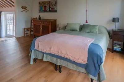 a bedroom with a bed and a wooden floor at Kleinhoef - charmante, luxe kamers in een boerderij uit 1875 in Nigtevecht