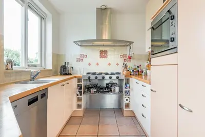 a kitchen with white cabinets and a stove at Villa Duin en Strand in Bergen aan Zee