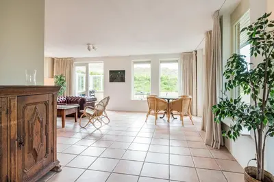 a living room with a table and chairs at Villa Duin en Strand in Bergen aan Zee