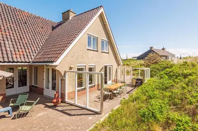 a house with sliding glass doors on a patio at Villa Duin en Strand in Bergen aan Zee