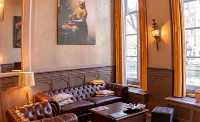 a living room with a leather couch and a table at Dutch Masters Short Stay Apartments in Amsterdam